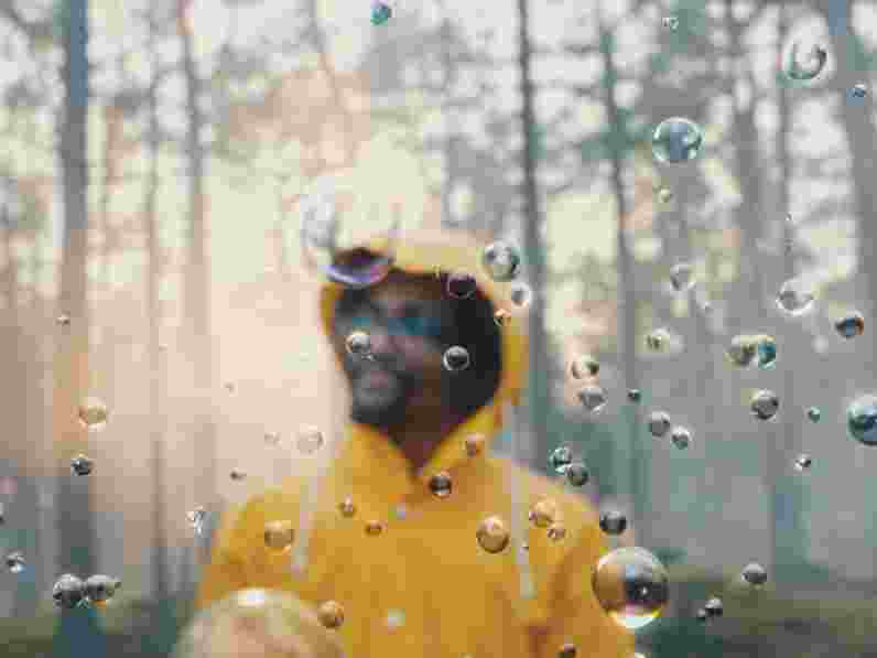 Man in yellow raincoat in forest